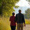 Ένα ζευγάρι που περπατάει χαρούμενα σε ένα φυσικό μονοπάτι, συμβολίζοντας την ήπια άσκηση